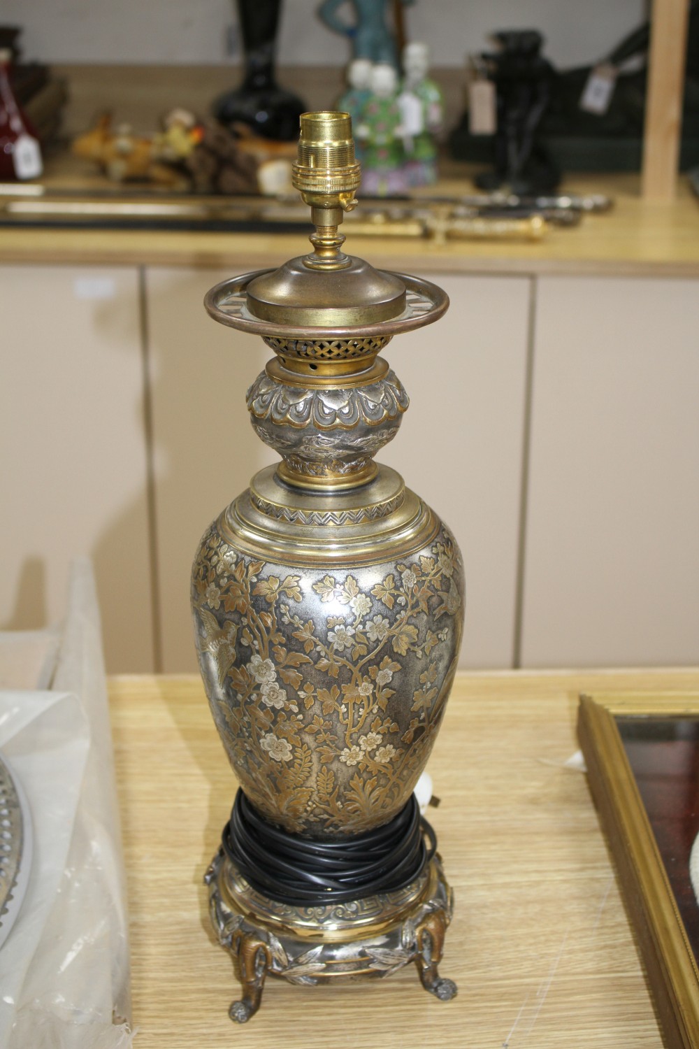 A 19th century French silvered and gilt brass table lamp, decorated with Oriental style flowers, scrolls and bamboo feet, overall heigh
